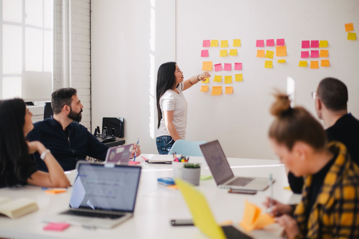 Marketing team reviewing an integrated campaign plan across multiple channels on a whiteboard