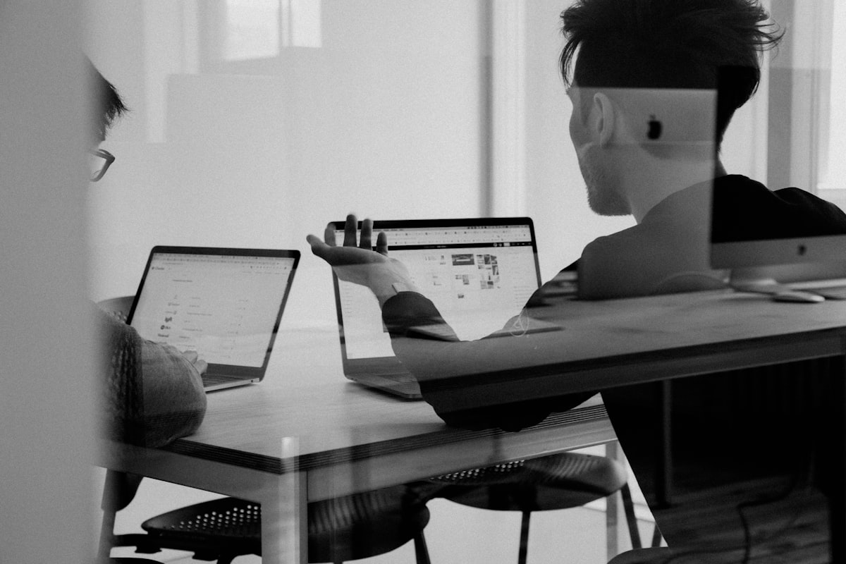 Customer service representative responding to customer messages across email, live chat, and social media on a multi-monitor setup