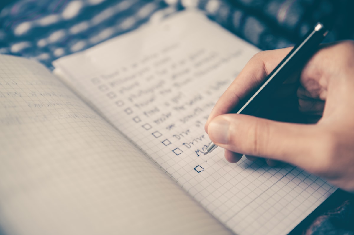 Notebook with email planning outline and laptop