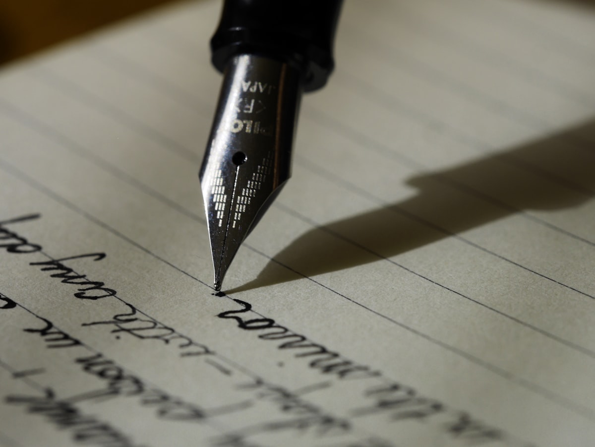 Person writing headlines in a notebook at a desk